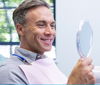 Man looking at smile in mirror