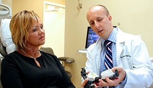 Vero Beach dentist showing a model of teeth to dental patient