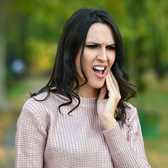 Woman in pain holding cheek