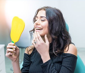 Woman looking at smile in mirror