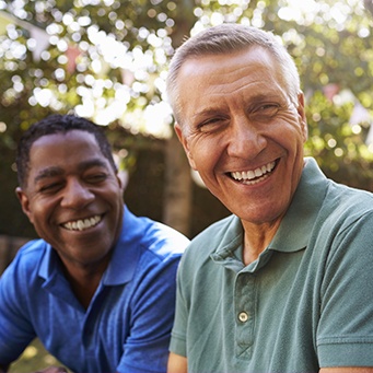 Two older men laughing outdoors