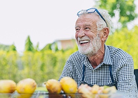 man smiling while sitting at outdoor table