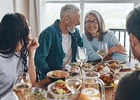 older couple laughing while eating dinner