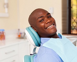person sitting in a dental treatment chair and smiling