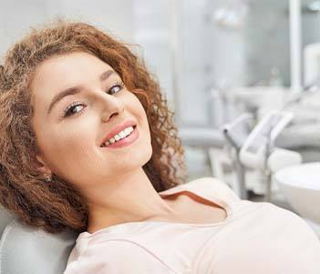 Woman sitting back and smiling after getting dental implants in Vero Beach, FL