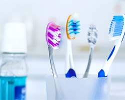 Toothbrushes in a cup with mouthwash nearby