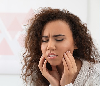 Woman holding jaw in pain