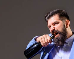 man opening bottle with teeth