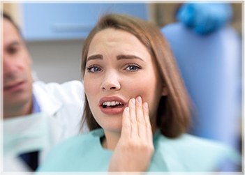 Woman in pain holding cheek