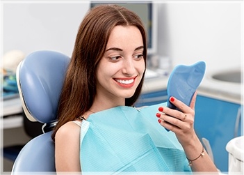 Young woman with beautiful smile in dental chair