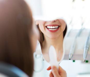 Woman looking at smile in mirror