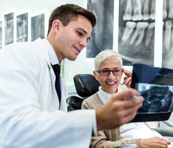 A male dentist showing a patient an X-ray