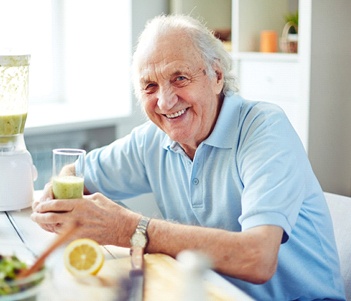 Happy older man enjoying a smoothie after dental treatment