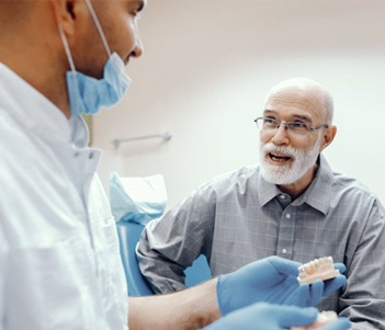 A senior patient speaking with a dentist about tooth replacement