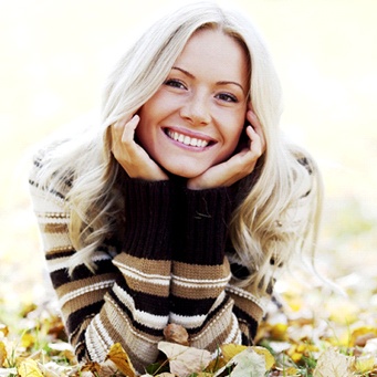 A young woman lying in the leaves and smiling