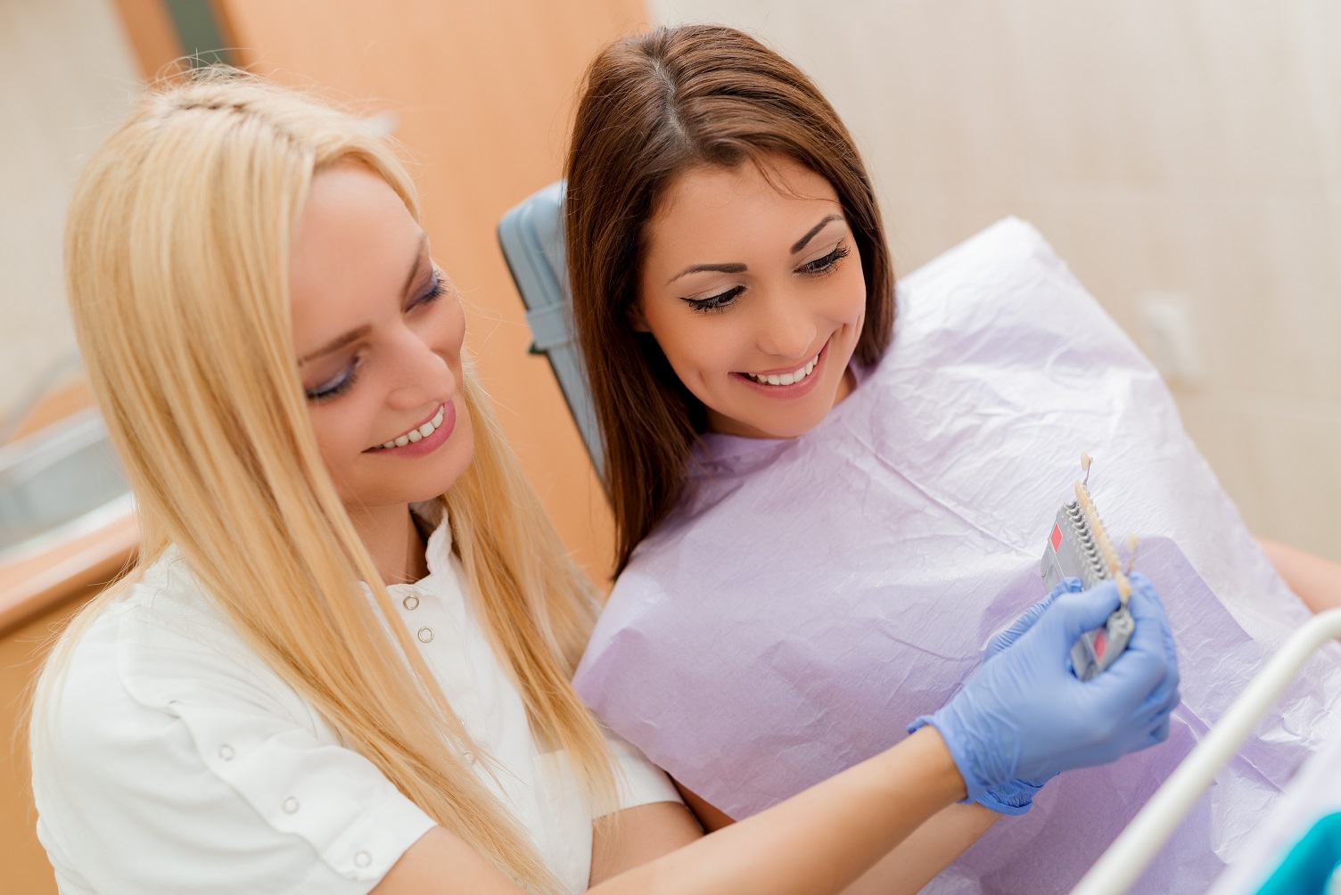 dentist and patient looking at teeth shading chart