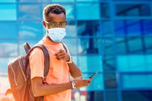 person with a mask on walking through a downtown area