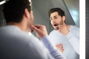 Man checking for a cavity between his teeth