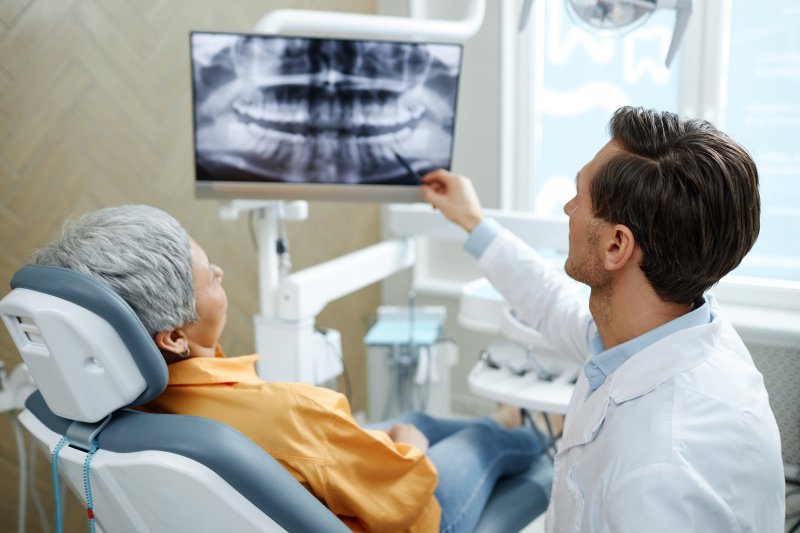 Patient with a prosthodontist near you looking at X-Rays
