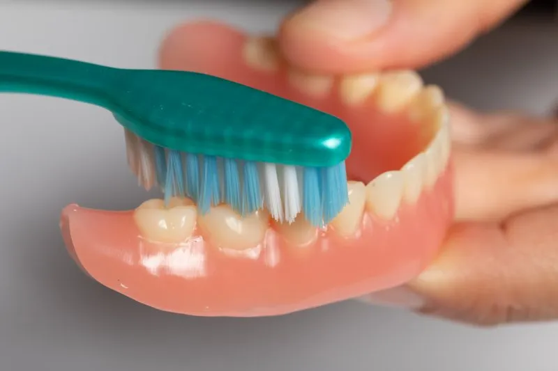 person caring for dentures